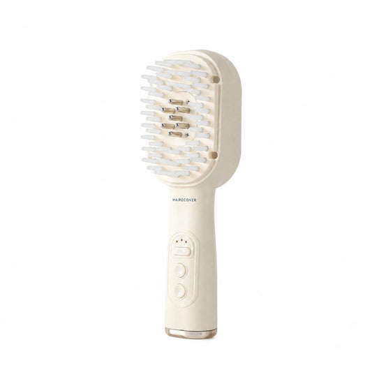 HAIRECOVER cream scalp brush with soft silicone tips and seven metal pins, front three-quarter view on white
