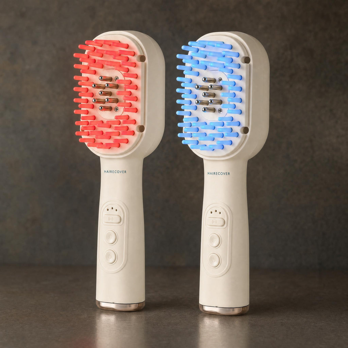 Two HAIRECOVER scalp brushes side by side, one with tips glowing red and one glowing blue